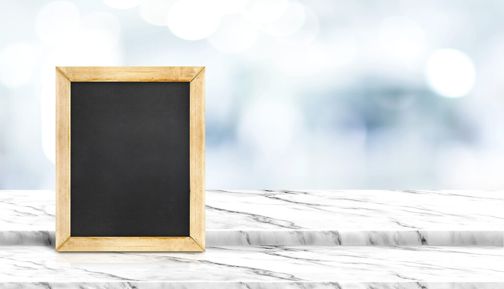 Blackboard on step white marble table top with blur patient wait